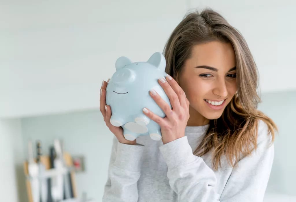 smiling person shaking piggy bank.jpg