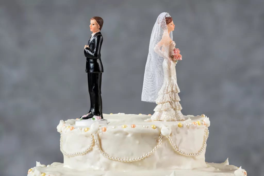 bride and groom figurines facing away from each other on top of wedding cake divorce marriage x afb.jpg
