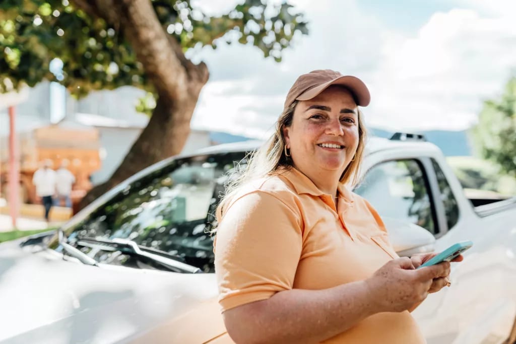 getty someone is standing by a car smiling.jpg