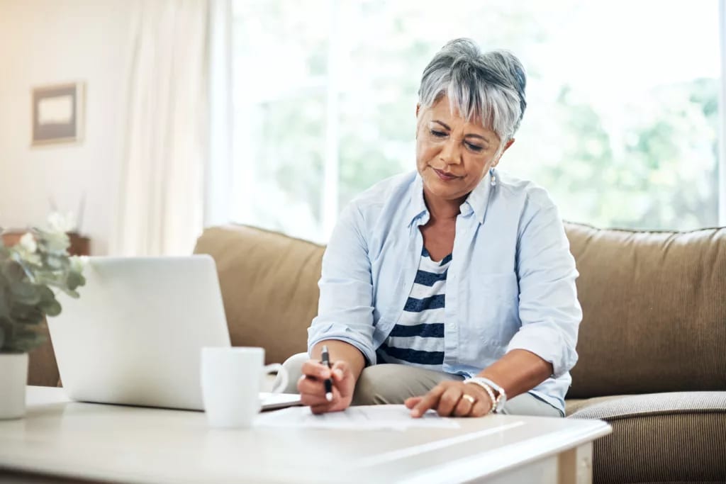person holding pen and looking at document on coffee table.jpg