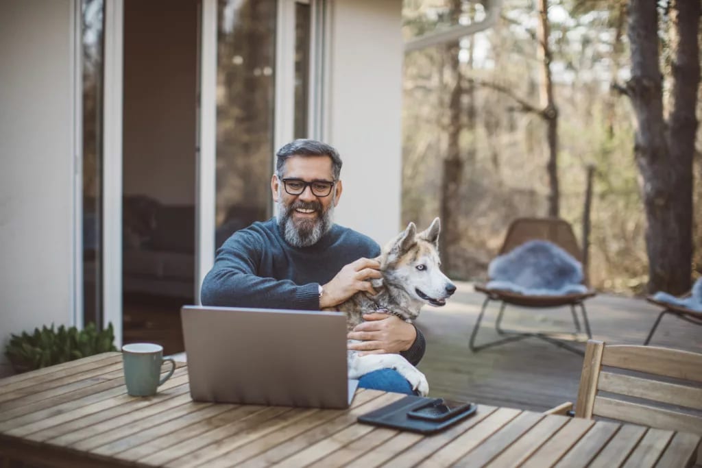 older man at laptop with dog gettyimages .jpg