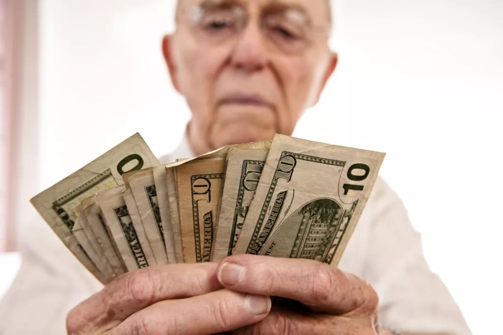 senior holding assortment cash bills social security retire getty.jpg