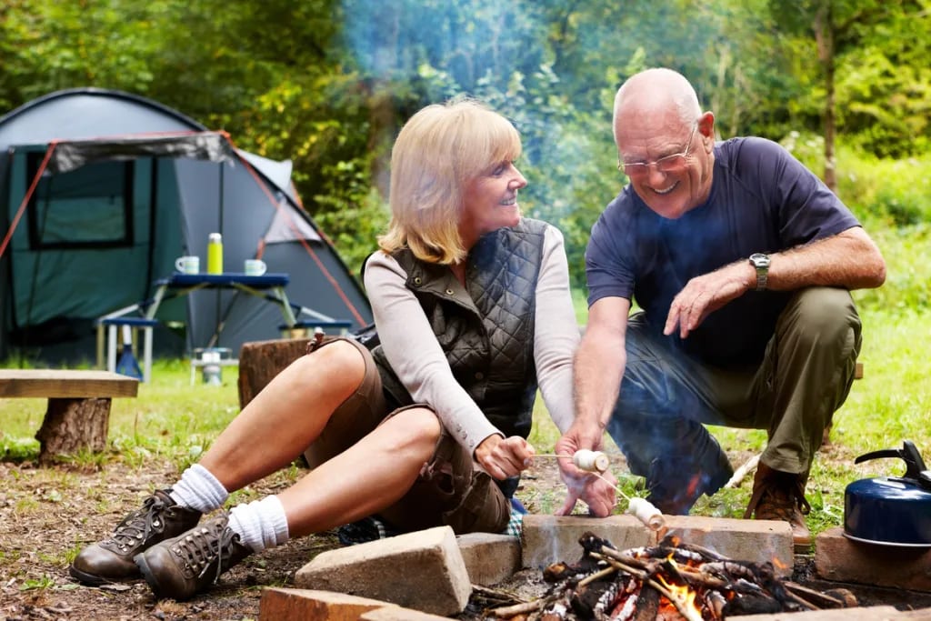 smiling couple roasting marshmallows at campsite.jpg