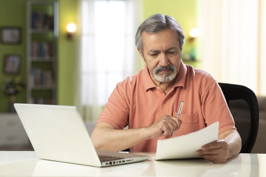 mature person holding pen and looking at document.jpg