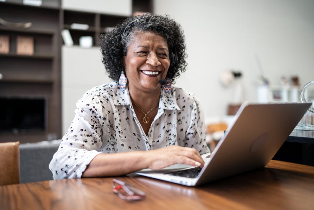 smiling person sitting in front of laptop.jpg
