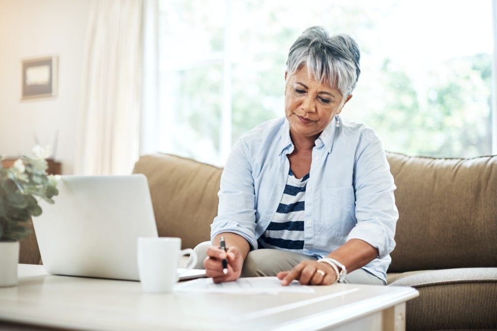 Person sitting at table looking at document.