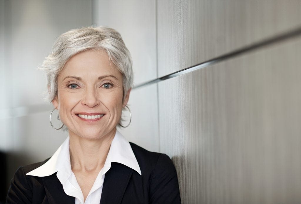 A smiling person in professional attire.