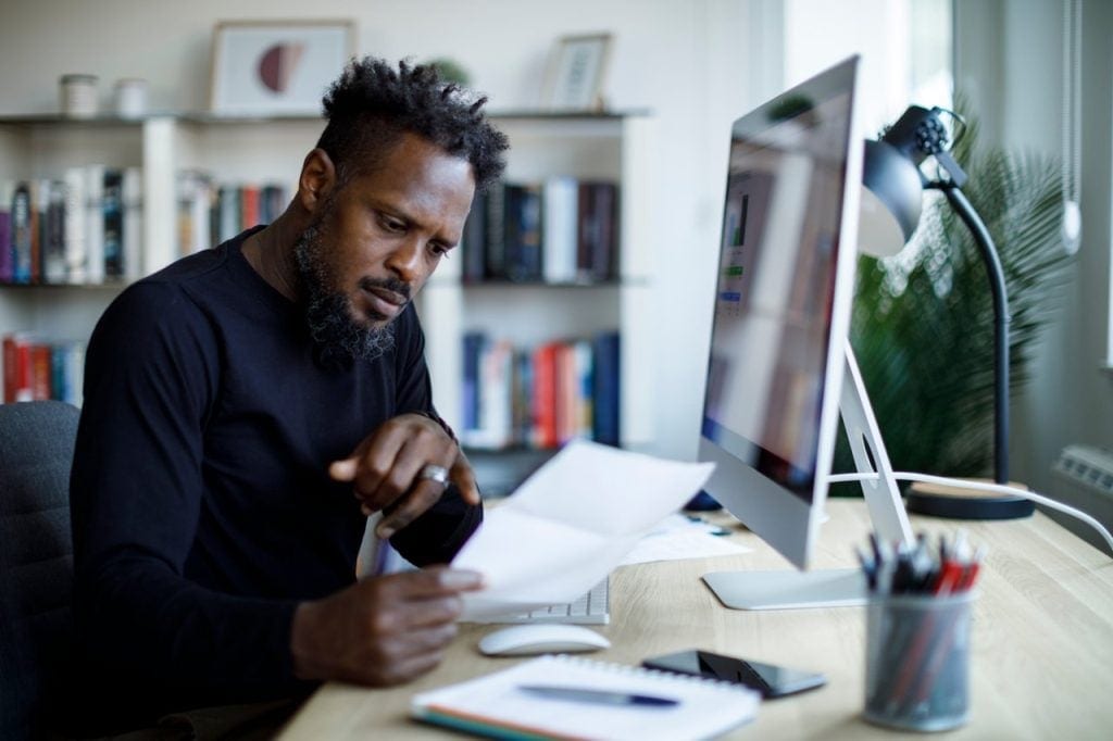 A person looking at paperwork confused or concerned.