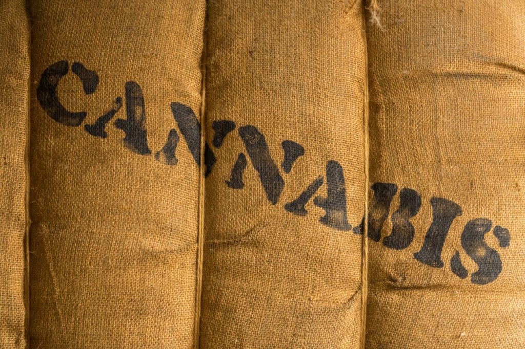 A large burlap sack with cannabis written on it.