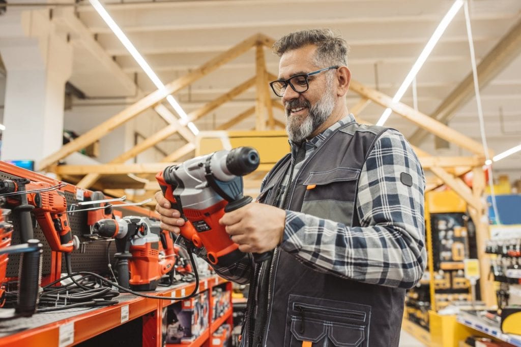 A person holding a power tool in a store.