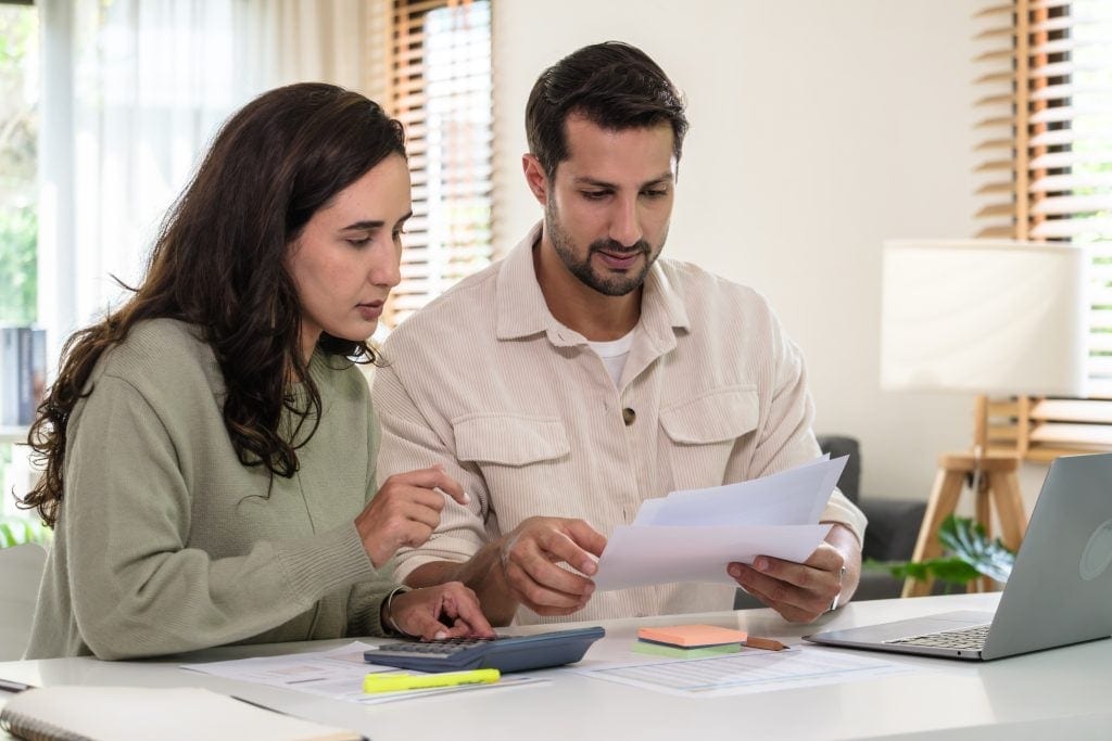 People sitting at their kitchen island, reviewing papers.