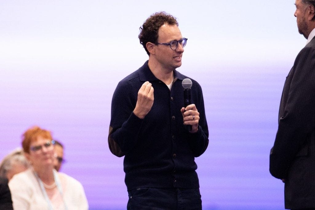Anthropic CEO Dario Amodei holding a microphone during a discussion.