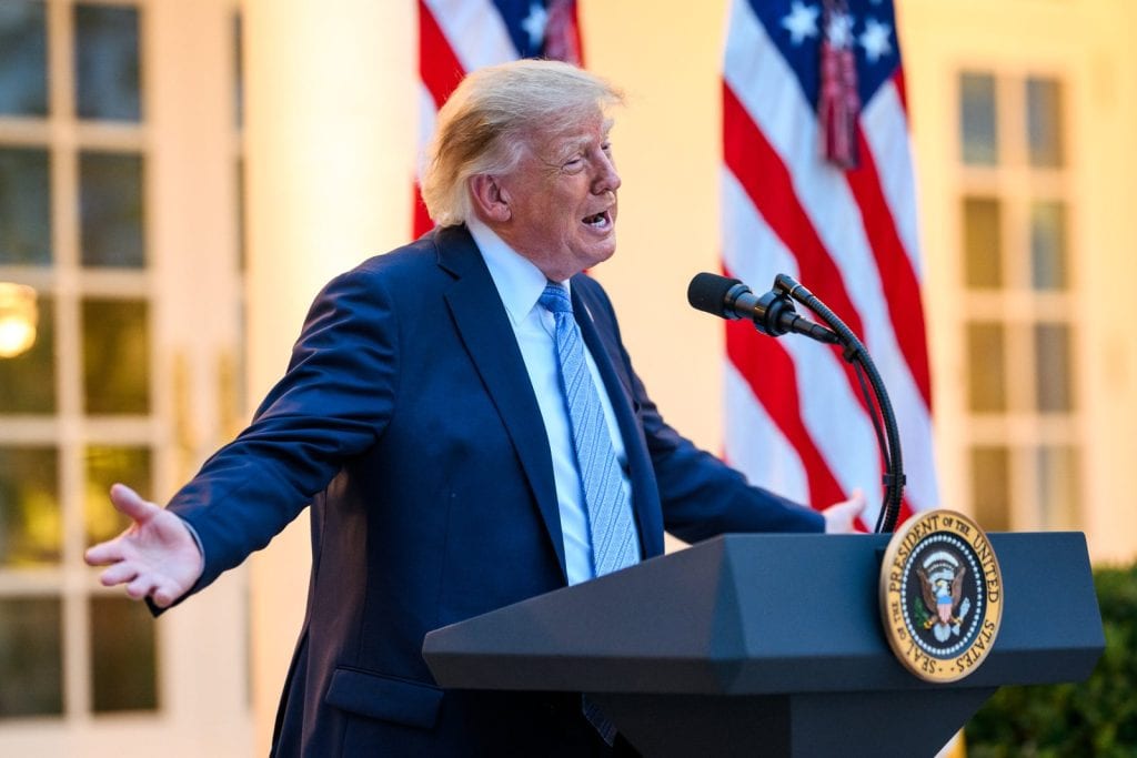 Donald Trump is speaking from behind a podium in the White House Rose Garden.