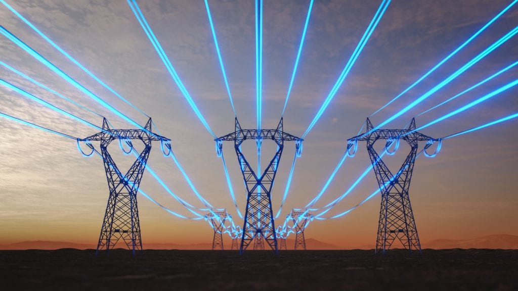 High-voltage transmission power lines glowing bright blue against the backdrop of a setting sun.
