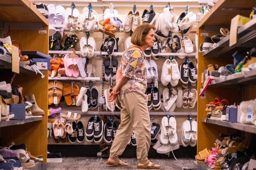 Someone shopping for sneakers in a store.