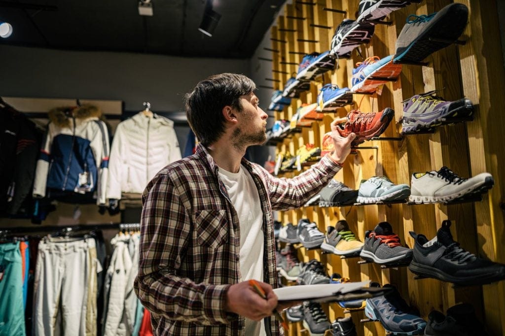 A customer shops for running shoes at an athletic apparel store.