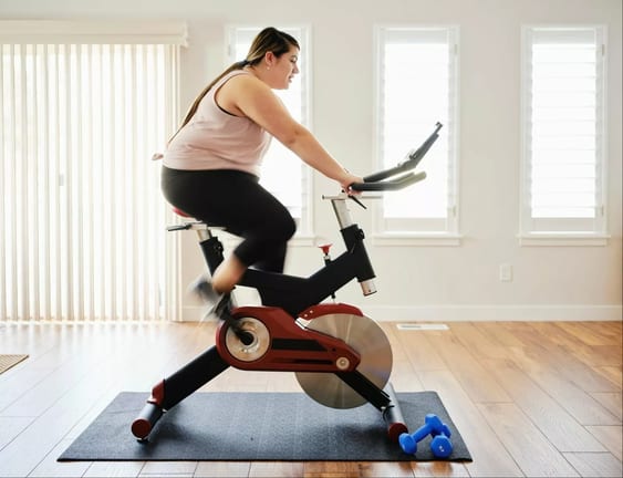 person on exercise bike at home kRawtlc.width .jpg