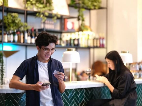 man in restaurant holding phone and credit ca.width UCoaDCF.jpg