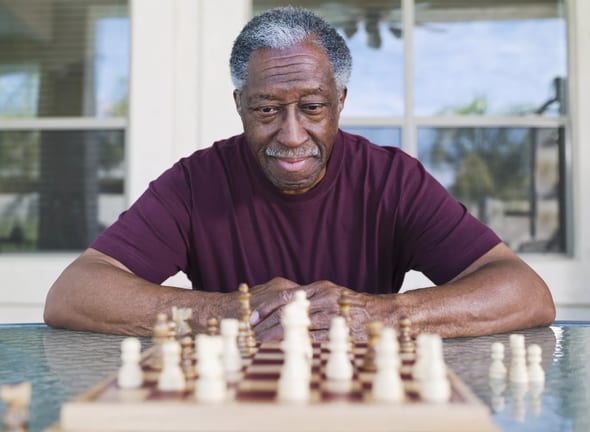 older man playing chess strategy moves winning.jpg