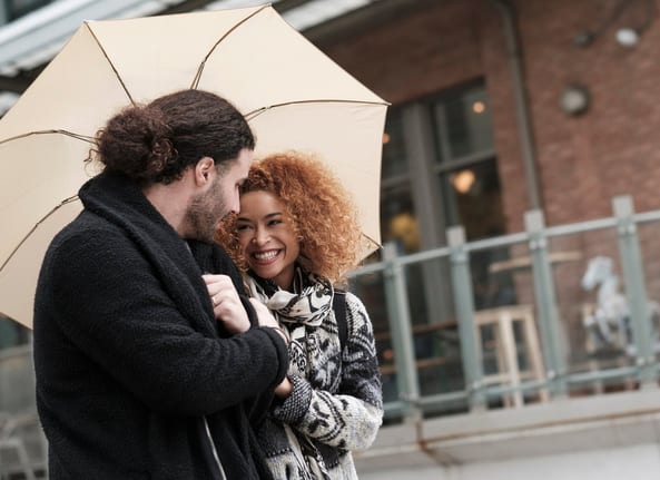 Couple walking through city under umbrella Ab.width .jpg