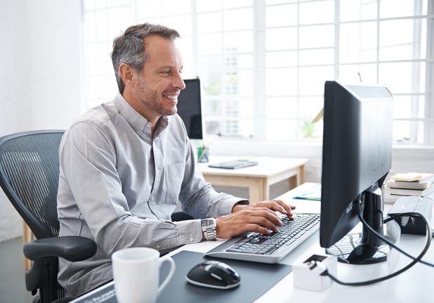 a smiling person at a computer gettyimages .jpg