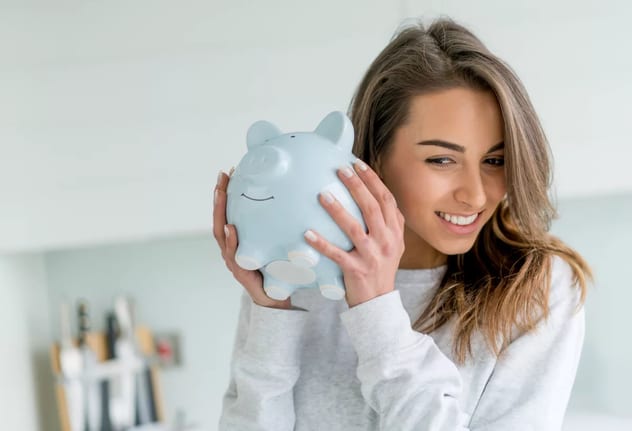 smiling person shaking piggy bank.jpg
