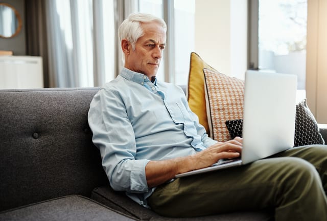 older man on laptop on couch gettyimages .jpg