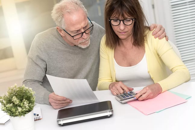 senior couple looking at calculator and documents.jpg