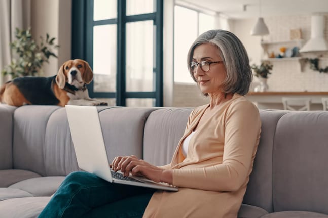 older woman laptop dog in background gettyimages .jpg