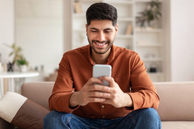investor smiling phone at home cMrY