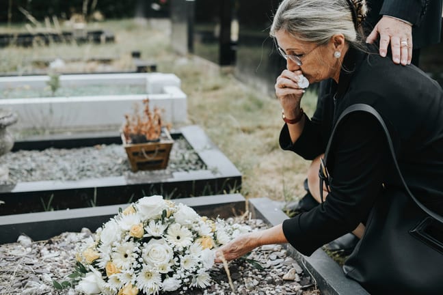 older woman at grave crying gettyimages laxCgb