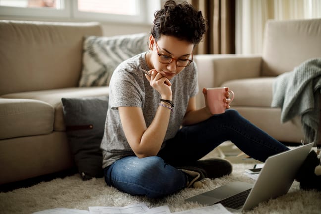 person sitting on floor looking at documents