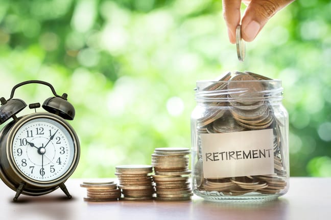 retirement savings jar full of coins and alarm clock