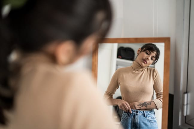 Person trying on clothing in mirror. EambWvL.width