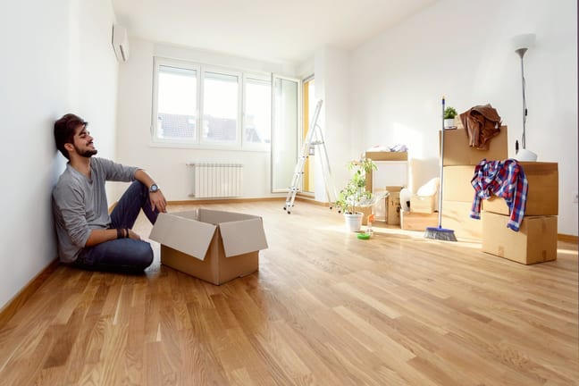 Young man empty apartment boxes imMTFem.width