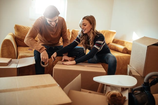 couple packing moving boxes.width