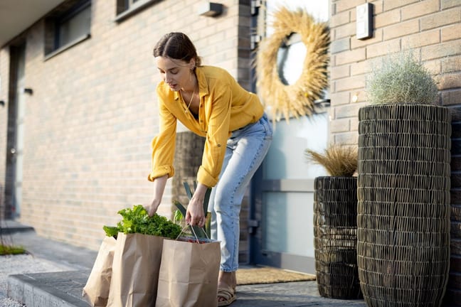 person with grocery bags at front door iQIVah.width .jpg