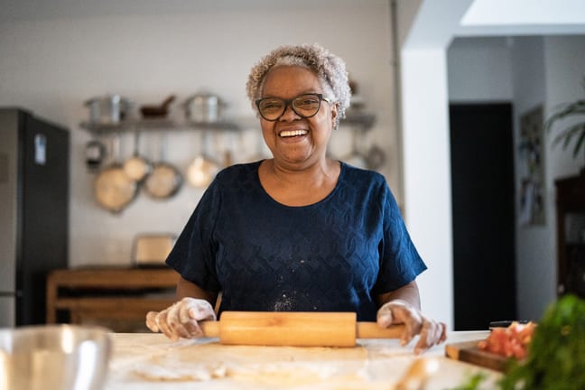 senior woman baking a smiling person holding a rolling pin gettyimages