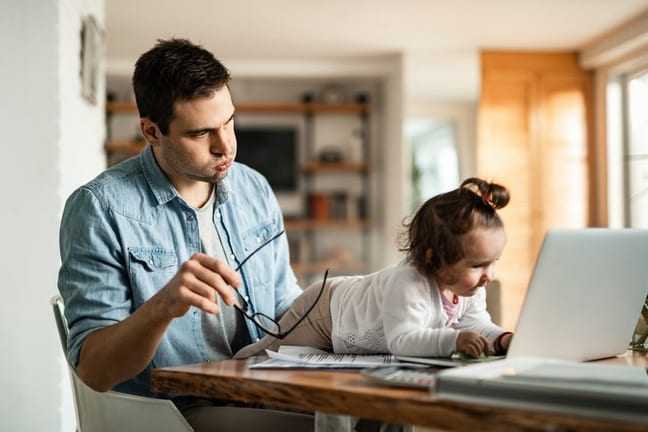 stressed dad working at home with baby.width