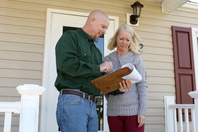 Woman on porch talking to man with clipboard .width .jpg