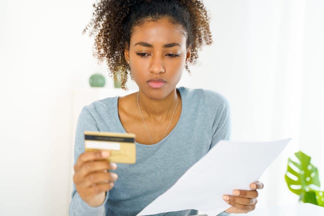 Young woman looking at credit card uQDfnW.width .jpg