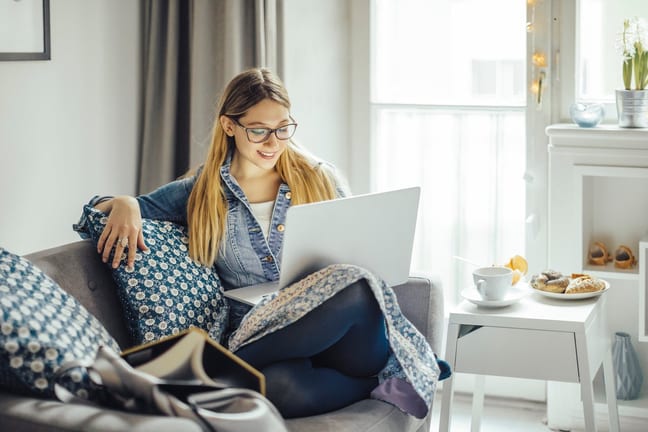 Young woman using laptop on the couch. KUYgdG.width .jpg
