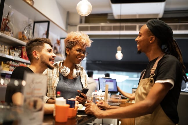 cafe employee with customers at counter Fzkr.width .jpg
