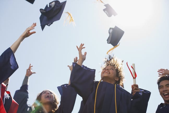 college graduates throwing mortarboards into .width mAUVTM.jpg