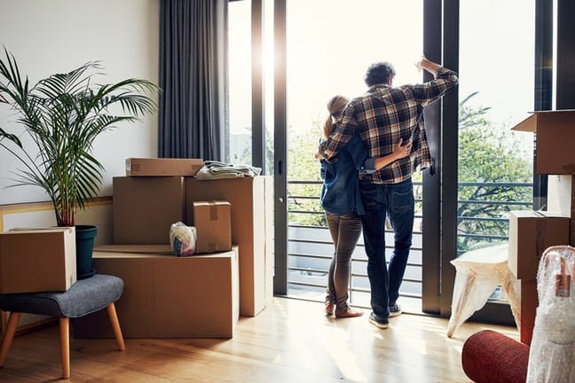 couple at window with moving boxes in new hom.width VeumdPo.jpg