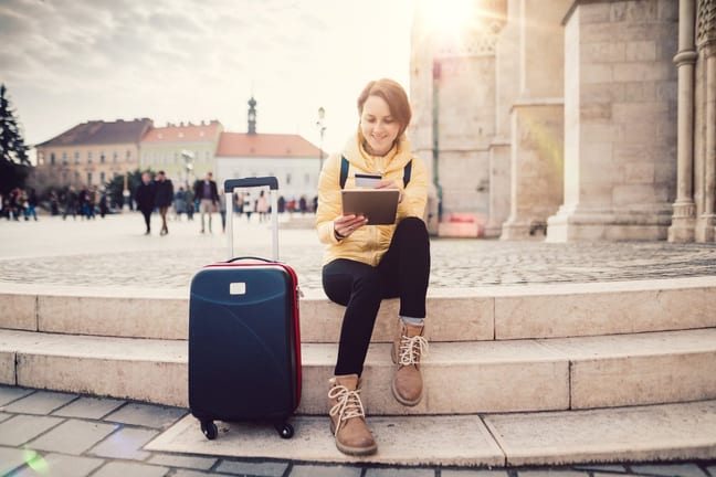 female traveler with suitcase tablet and cred.width sQbWMG.jpg