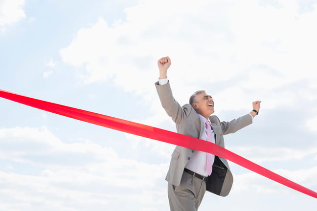 mature man businessman crossing finish line.jpg