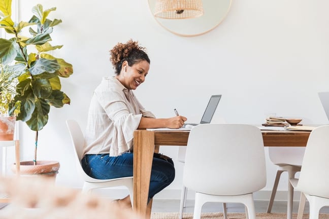 person at dining table writing in notebook TR.width .jpg