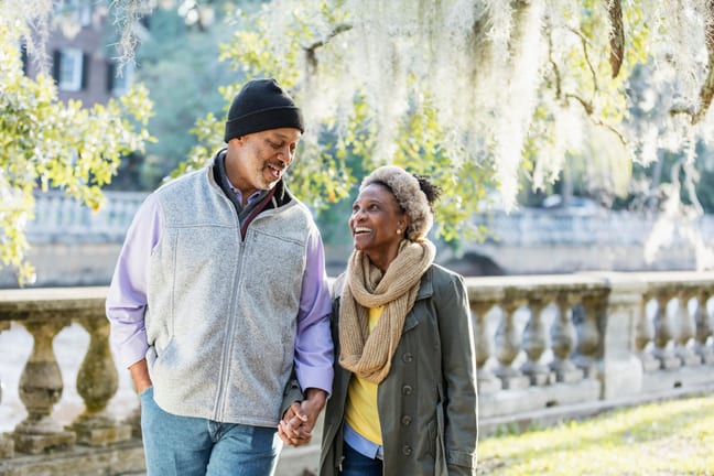 two older people walking in the park holding handds.jpg