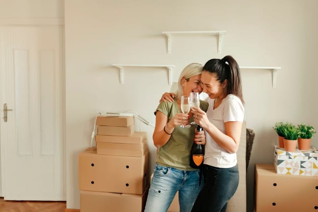 two people with champagne and moving boxes T.width .jpg